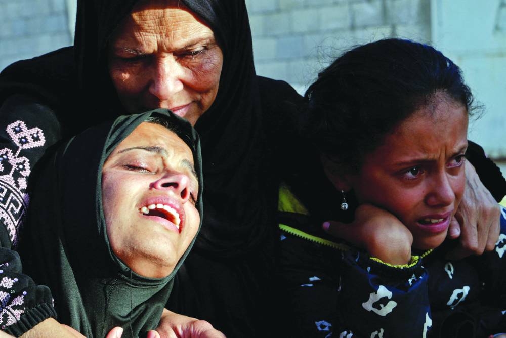 Women react near the bodies of Palestinians killed in Israeli strikes, at Nasser Hospital, in Khan Younis, in the southern Gaza Strip, yesterday.