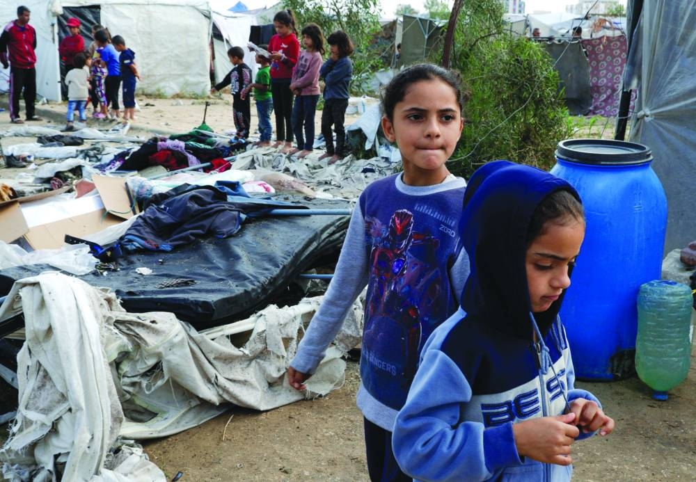 Children gather at the site of an Israeli strike on a tent sheltering displaced people, in Khan Younis in the southern Gaza Strip, yesterday.