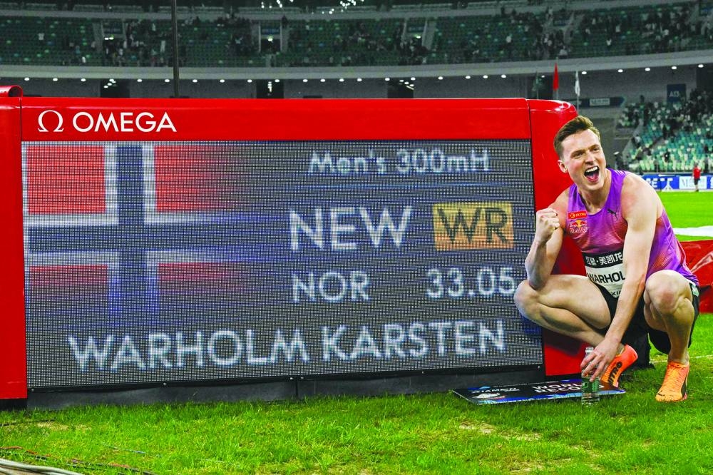 Norway’s Karsten Warholm poses with his time of 33.05 seconds after he broke the men’s 300m hurdles world record during the Xiamen IAAF Diamond League athletics meeting in Xiamen, China, on Saturday. (AFP)