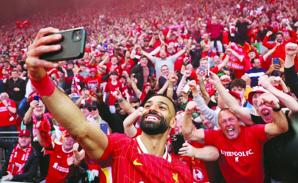 Liverpool’s Mohamed Salah takes a selfie with fans after winning the Premier League title on Sunday. (Reuters)