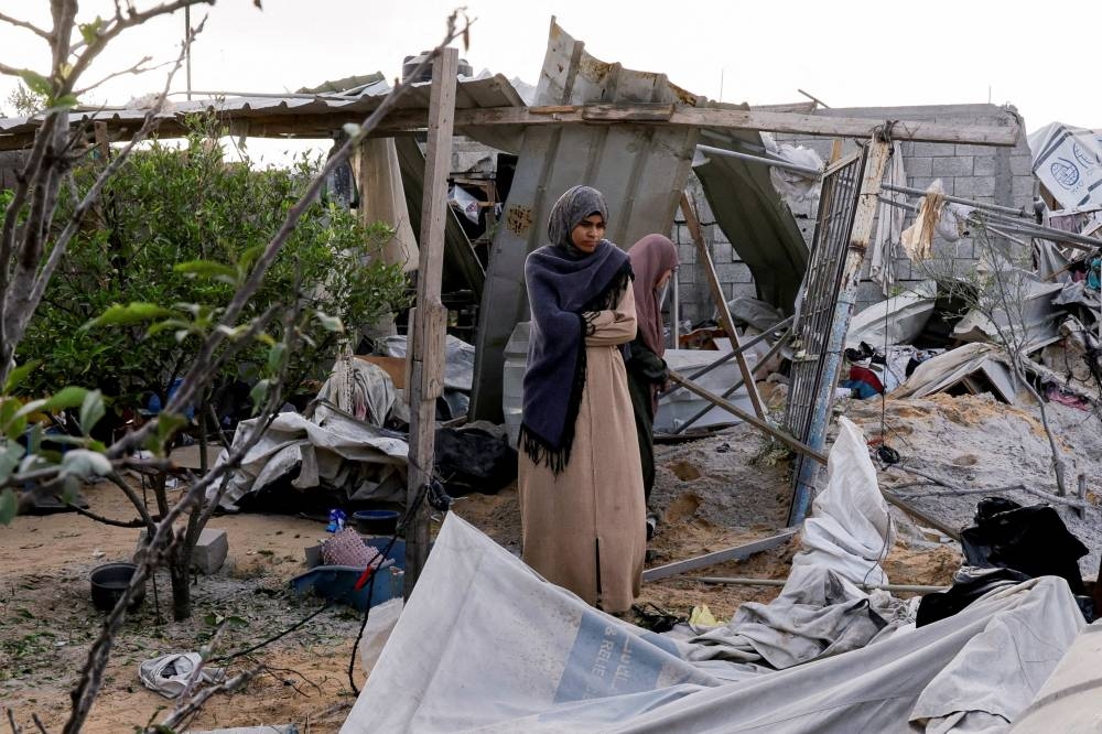 Palestinians stand at the site of an Israeli strike on a tent camp in Khan Younis, southern Gaza Strip, Wednesday.