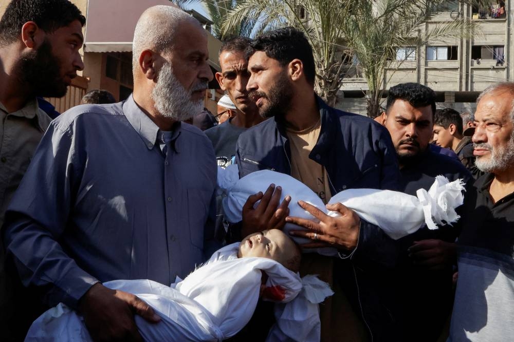 People carry the dead bodies of children as they attend the funeral of Palestinians killed in Israeli strikes, in Khan Younis, southern Gaza Strip, on Saturday. REUTERS