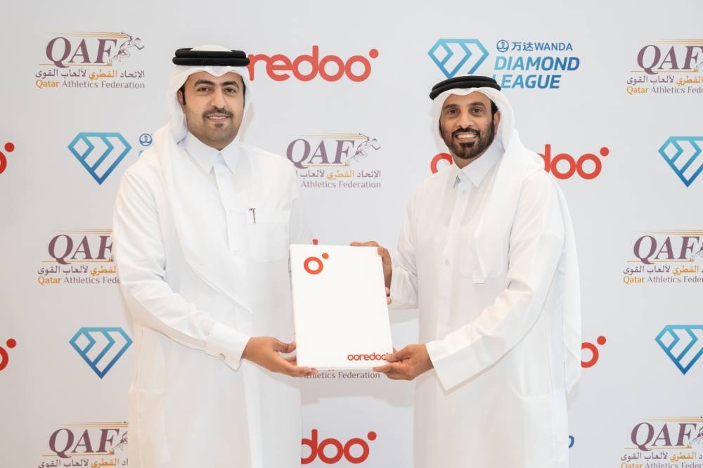Sabah al-Kuwari, Senior Director Marketing Communications at Ooredoo, and Mohammed Issa al-Fadala, President of the Qatar Athletics Federation, after a sponsorship signing ceremony.