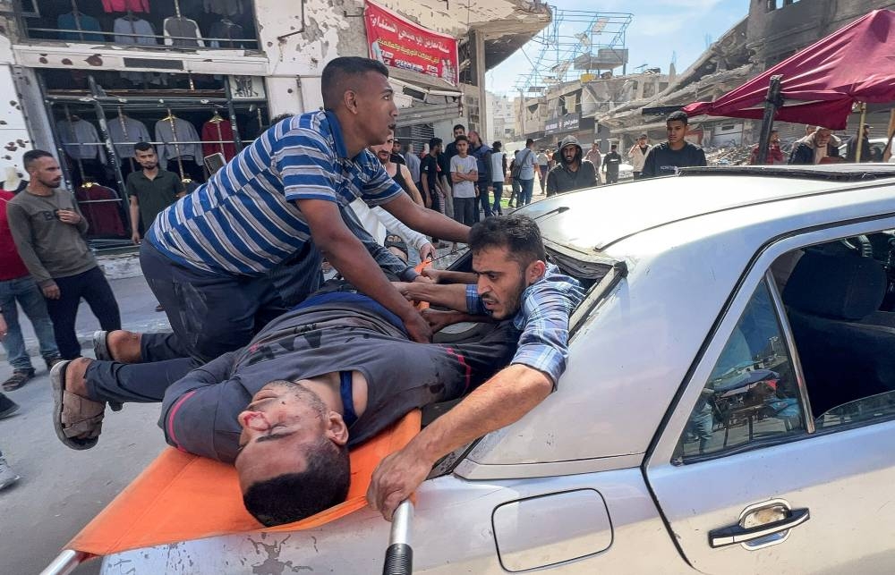 Palestinians carry a victim after an Israeli airstrike, in Gaza City, on Wednesday. REUTERS