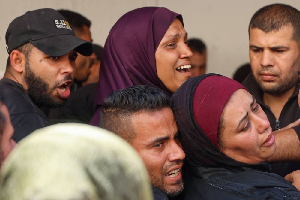 Palestinians mourn the death of loved ones at the Al-Ahli hospital, also known as the Baptist or Ahli Arab hospital, before a funeral procession on Wednesday, following an Israeli strike in Gaza City. AFP