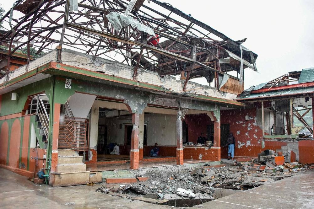 Kashmiri Muslims arrive to attend Friday prayers at a damaged mosque following Indian strikes in Muzaffarabad, the capital of Pakistan-administered Kashmir, Friday. AFP