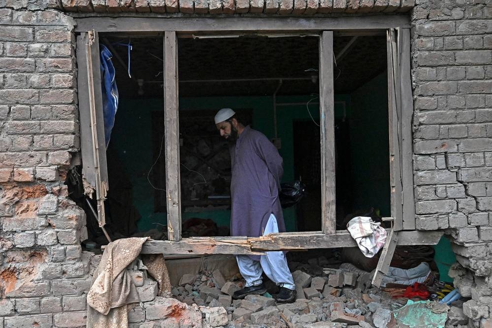 A local resident inspects his house that was damaged by Pakistani artillery shelling in Uri, about 100kms from Srinagar, on Friday. AFP