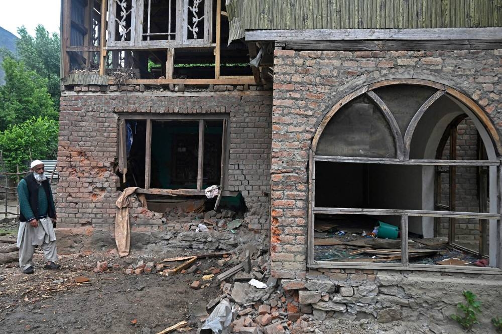A local resident inspects his house that was damaged by Pakistani artillery shelling in Uri, about 100kms from Srinagar, on Friday. AFP