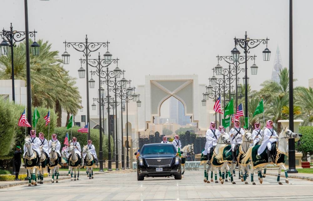 The car carrying US President Donald Trump is pictured between Saudi honor guards on horses carrying US and Saudi flags, during a welcoming ceremony at the Royal Court in Riyadh, Saudi Arabia, Tuesday. Saudi Press Agency/Handout via REUTERS