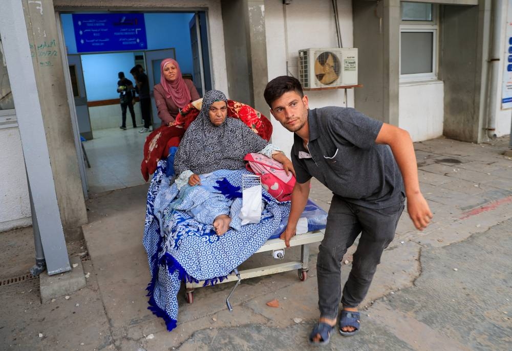 A Palestinian patient is evacuated from the European Hospital, after it was partially damaged in Israeli airstrikes, according to the Gaza Health Ministry, in Khan Younis, in the southern Gaza Strip, on Tuesday. REUTERS