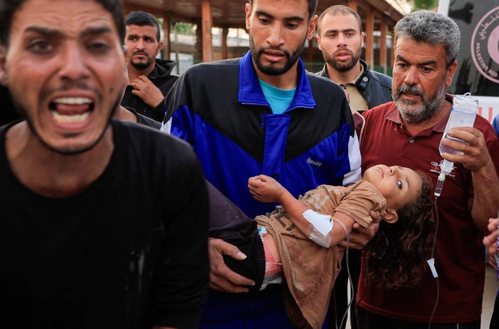 A Palestinian man carries a wounded child, after the European Hospital was partially damaged following Israeli airstrikes, according to the Gaza Health Ministry, in Khan Younis, in the southern Gaza Strip, on Tuesday. REUTERS