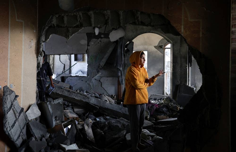 A Palestinian stands in a building damaged in an Israeli strike, in Khan Younis, in the southern Gaza Strip, on Thursday. REUTERS