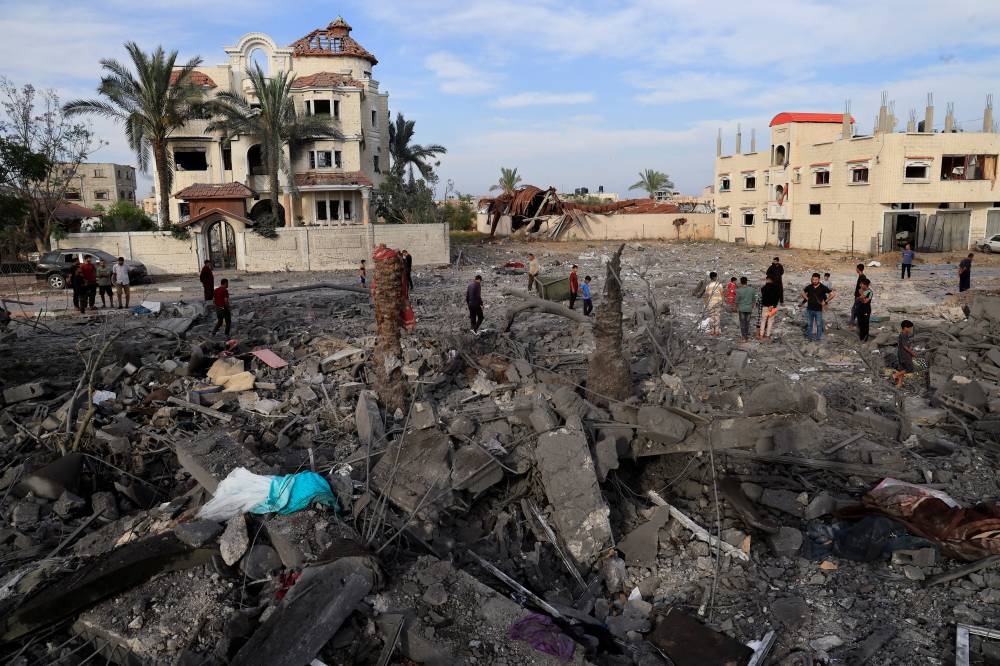 Palestinians inspect the site of an Israeli strike on a house, in Khan Younis, in the southern Gaza Strip, on Thursday. REUTERS