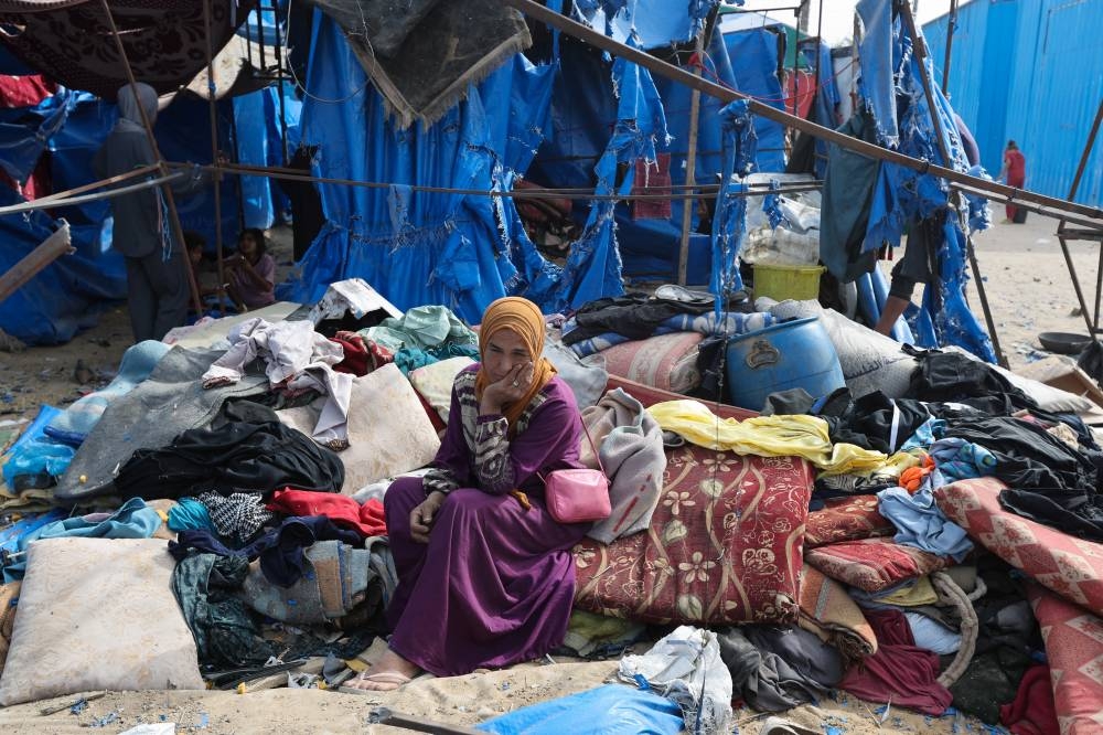 A Palestinian woman sits at the site of an Israeli airstrike on a tent sheltering displaced people, in Deir Al-Balah in the central Gaza Strip, on Saturday. REUTERS