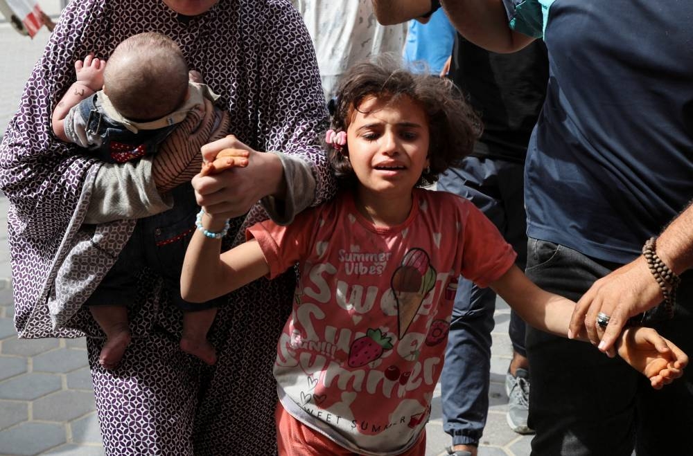 A girl reacts as Palestinians carry wounded people to Al-Aqsa Martyrs hospital, following an Israeli strike, in Deir Al-Balah, central Gaza Strip, on Saturday. REUTERS