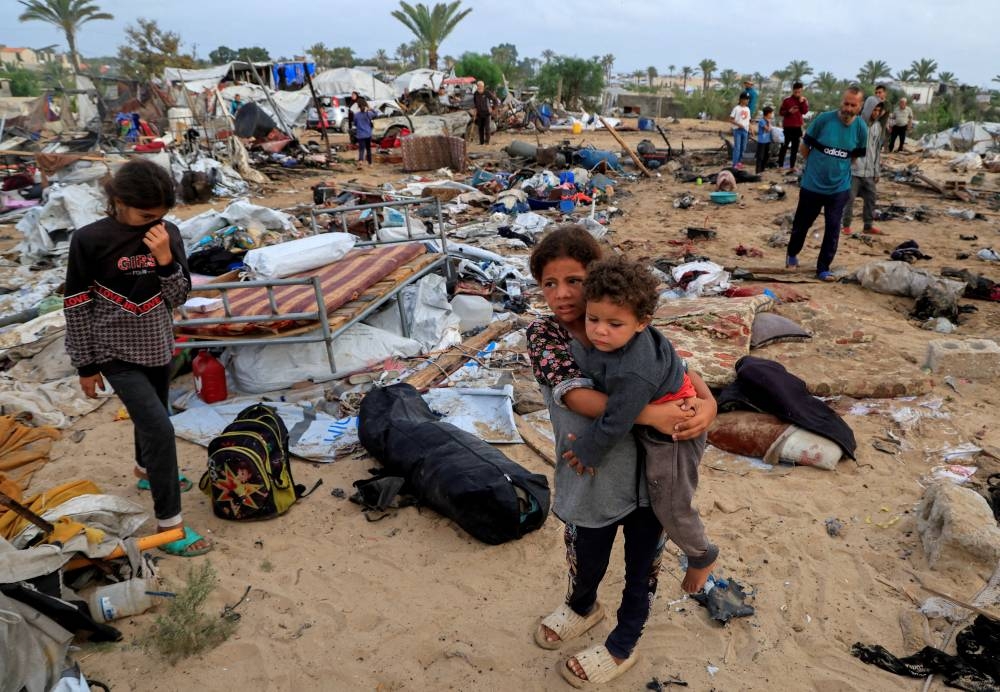 Palestinians inspect the damage at the site of an Israeli strike on a tent camp sheltering displaced people, in Khan Younis, southern Gaza Strip, on Sunday. REUTERS