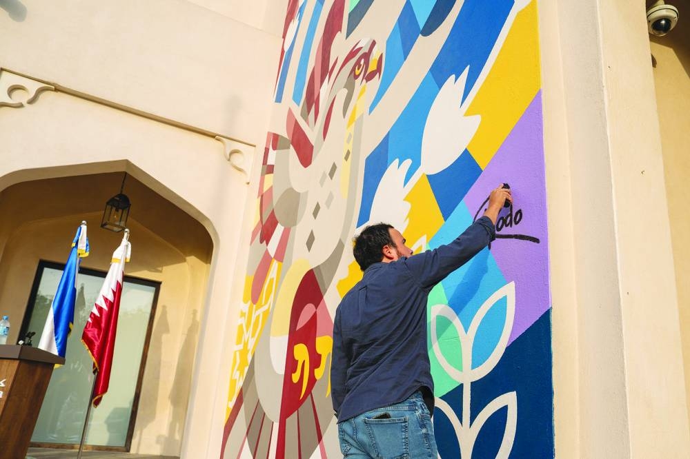 El Salvadoran artist Rodolfo Díaz lends the finishing touches to his mural at Katara Cultural Village.