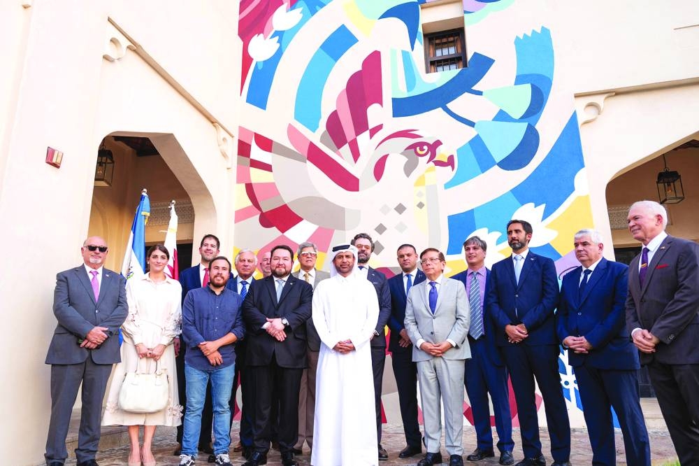 The mural Meeting of Horizons is seen on the facade of Building No. 43 in Katara Cultural Village with dignitaries in front of it during the unveiling ceremony.