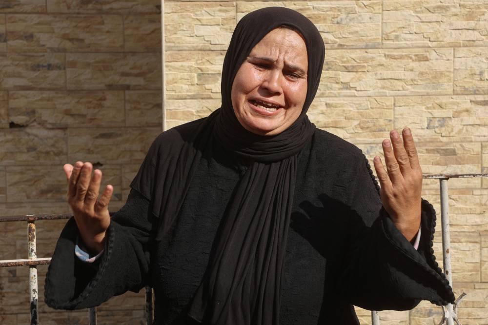 A Palestinian woman mourns at Gaza City's Al-Ahli Arab hospital, also known as the Baptist hospital, following an Israeli airstrike that hit an UNRWA school, serving as a shelter for people who left their homes in the besieged Palestinian territory, on Tuesday. AFP