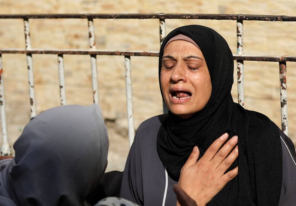 A mourner reacts during the funeral of Palestinians killed in Israeli strikes, at Al-Ahli Arab Baptist hospital, in Gaza City, on Tuesday. REUTERS