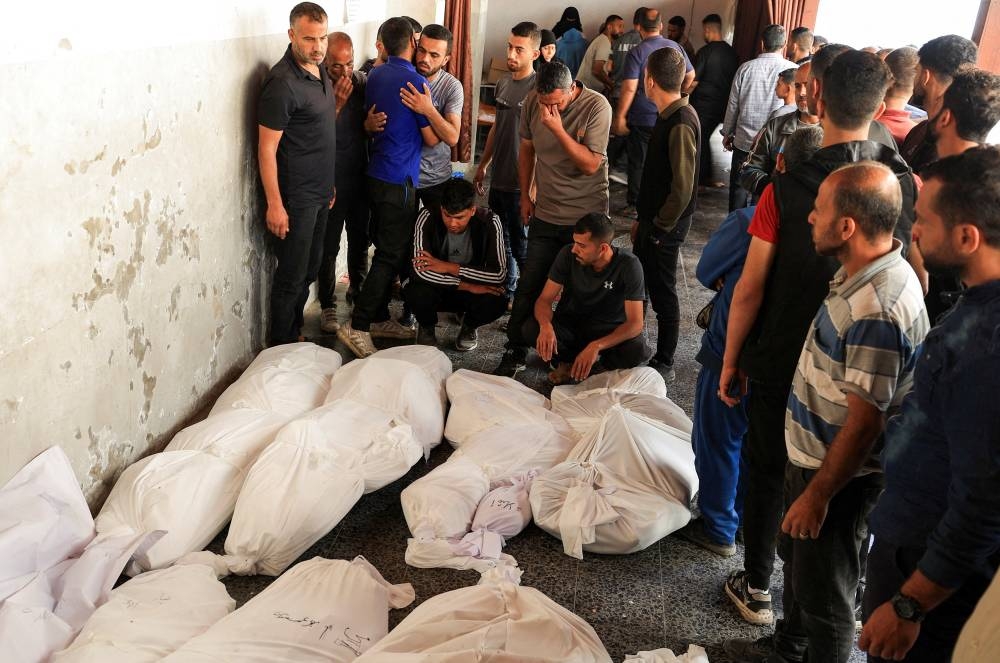 Mourners react next to the bodies of Palestinians killed in Israeli strikes, during the funeral at Al-Ahli Arab Baptist hospital, in Gaza City, on Tuesday. REUTERS