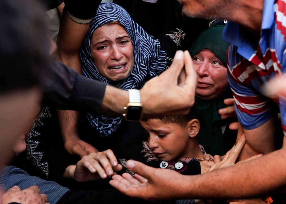 Mourners react as they attend the funeral of Palestinians killed in Israeli strikes, at Nasser hospital, in Khan Younis, in the southern Gaza Strip, on Friday. REUTERS