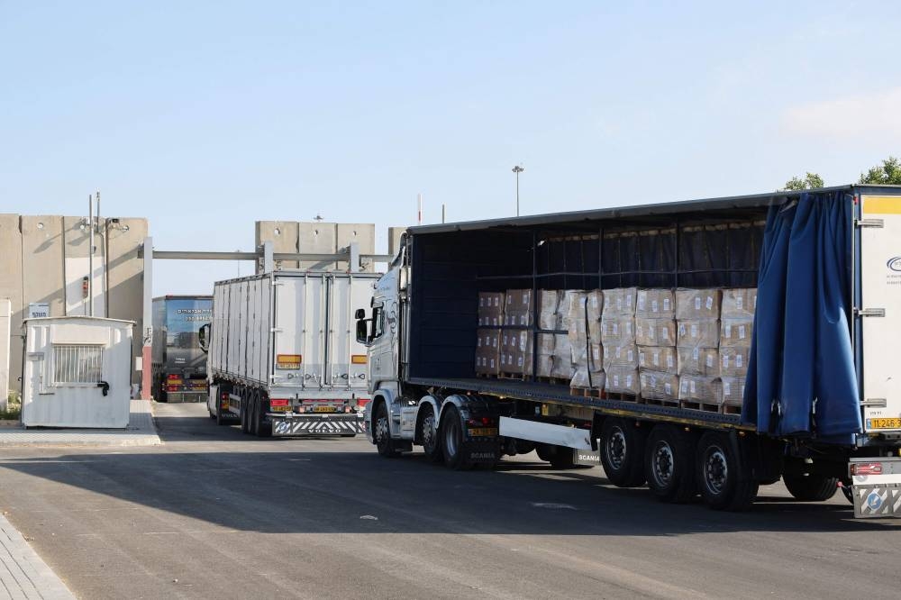 Trucks carrying humanitarian aid drive through the Kerem Shalom crossing between southern Israel and the Gaza Strip, on Thursday. AFP