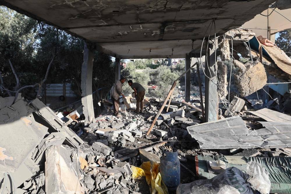 Palestinians inspect the damage inside a house targeted in an Israeli strike at the Nuseirat camp for refugees in the central Gaza Strip on on Saturday. AFP