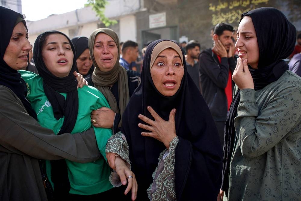Women mourn relatives killed in an Israeli strike, at Al-Shifa hospital in Gaza City on Monday. AFP