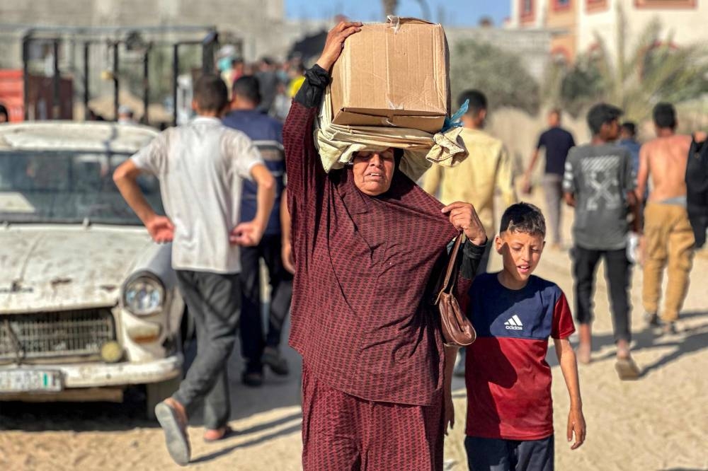 Displaced Palestinians receive food packages  in western Rafah Tuesday.