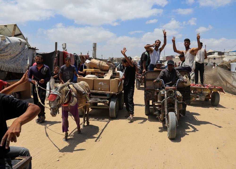 Palestinians carry aid supplies they received from the U.S.-backed Gaza Humanitarian Foundation, in Khan Younis, in the southern Gaza Strip, on Wednesday. REUTERS