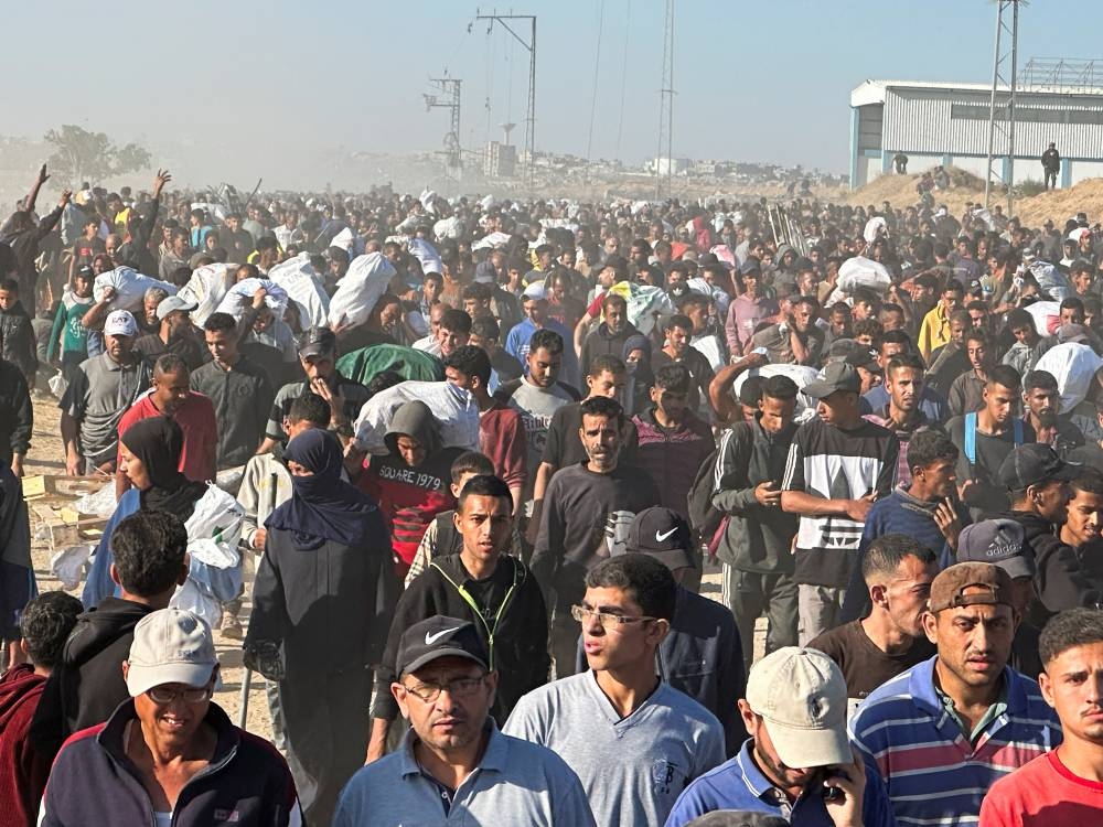 Palestinians carry aid supplies they received from the US-backed Gaza Humanitarian Foundation, in Khan Younis, in the southern Gaza Strip, on Thursday. REUTERS