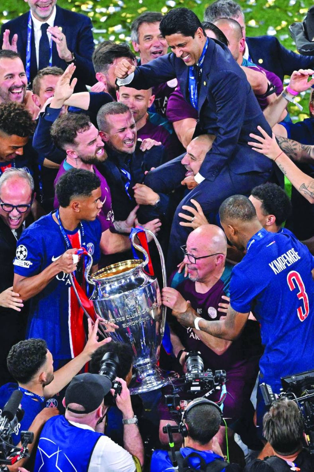 Paris Saint Germain's Qatari president Nasser al-Khelaifi (top R) celebrates with players and the trophy after the UEFA Champions League final match between Paris Saint-Germain (PSG) and Inter Milan in Munich, Saturday. PSG won the final 5-0.