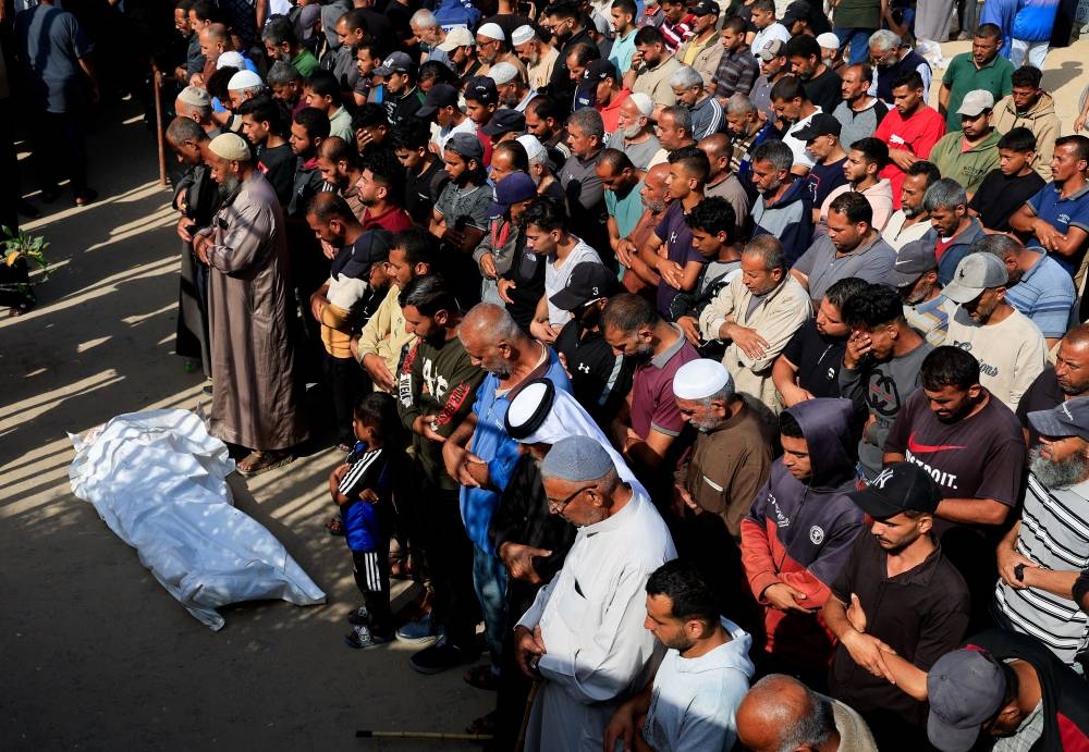 Mourners pray during the funeral of Palestinians killed in Israeli strikes, at Nasser hospital, in Khan Younis, in the southern Gaza Strip, on Sunday. REUTERS