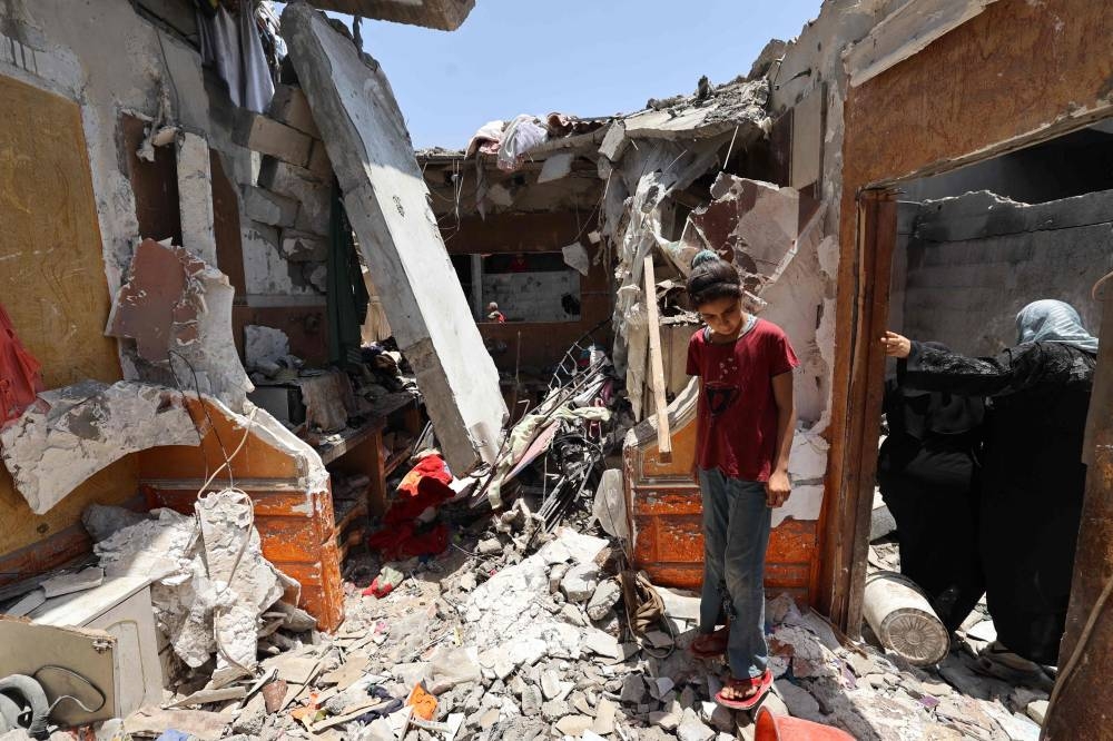 A child stands in the rubble of a house targeted in an Israeli strike in the Nuseirat camp for Palestinian refugees in the central Gaza Strip, on Sunday. AFP