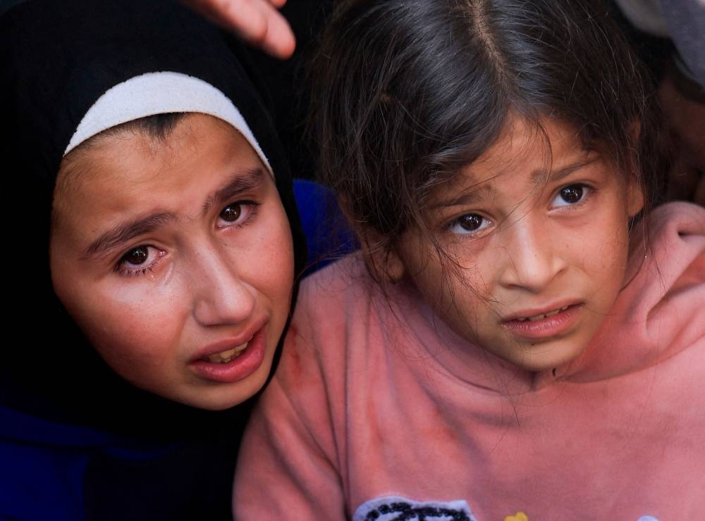 Children react during the funeral of Palestinians killed in Israeli strikes, at Nasser hospital, in Khan Younis, in the southern Gaza Strip, on Sunday. REUTERS