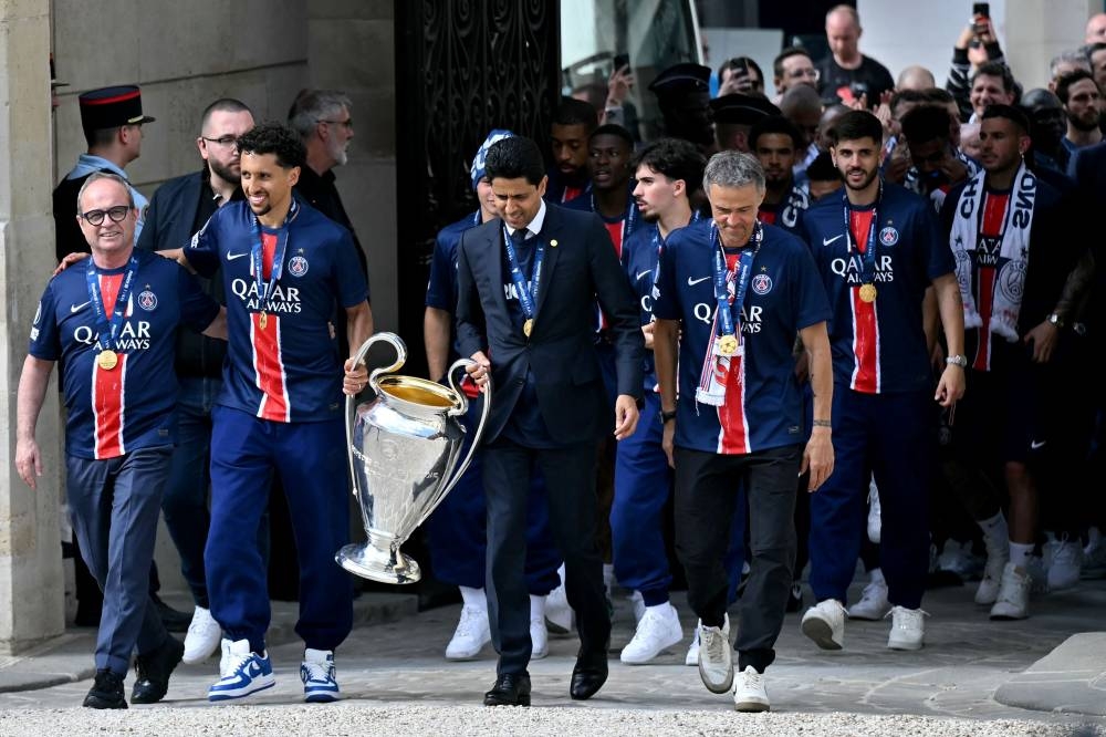 Paris Saint-Germain's Brazilian defender #05 Marquinhos (2L), Paris Saint Germain's Qatari president Nasser al-Khelaifi (C), Paris Saint-Germain's Spanish coach Luis Enrique (R) and PSG's players arrive for a reception at the Elysee presidential palace in Paris on on Sunday. AFP