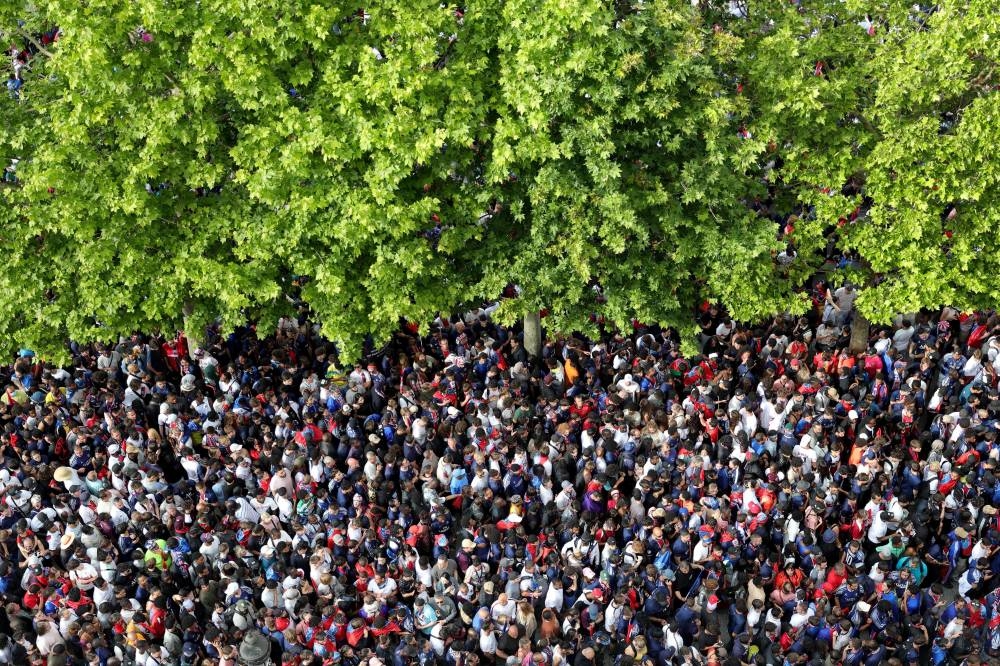 Spectators gather to watch Paris Saint-Germain's team players and staff celebrate during the bus parade on the Champs-Elysees avenue in Paris on Sunday. AFP