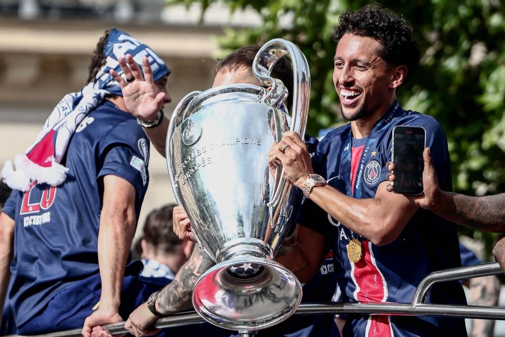 Paris Saint-Germain's Brazilian defender #05 Marquinhos holds the UEFA Champions League Trophy as they parade on the Champs-Elysees avenue in Paris on Sunday. AFP