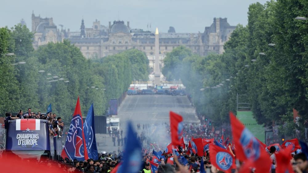 Paris St Germain players celebrate after winning the Champions League on the bus during the victory parade. REUTERS