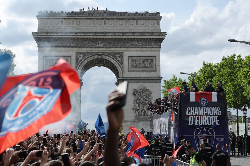 Paris St Germain players celebrate after winning the Champions League on the bus in front of the Arc de Triomphe during the victory parade REUTERS