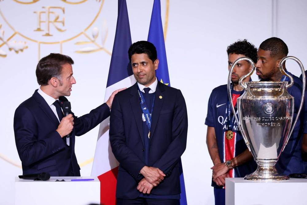 France's President Emmanuel Macron (L) gestures toward Paris Saint Germain's Qatari president Nasser al-Khelaifi (C), next to Paris Saint-Germain's Brazilian defender #05 Marquinhos (2nd-R) and Paris Saint-Germain's French defender #03 Presnel Kimpembe during the reception at the Elysee presidential palace in Paris on on Sunday. AFP
