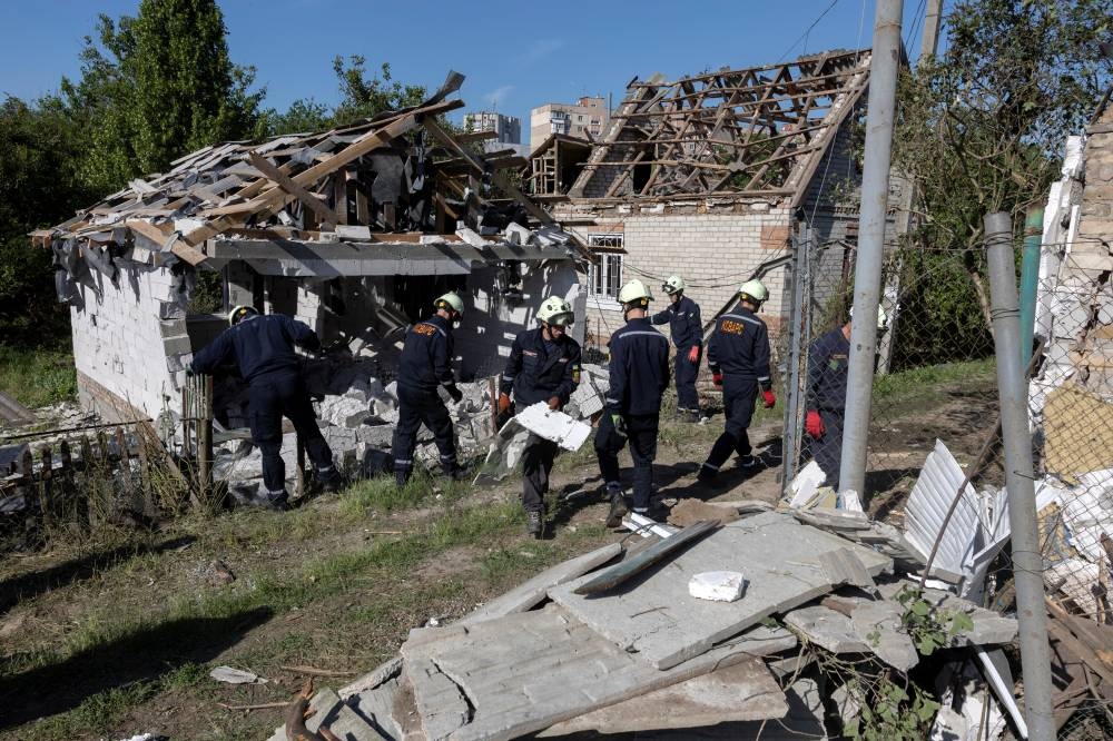 Emergency workers remove debris from a private house that was damaged in a Russian drone strike, amid Russia's attack on Ukraine, in Zaporizhzhia, Ukraine, on Monday. REUTERS