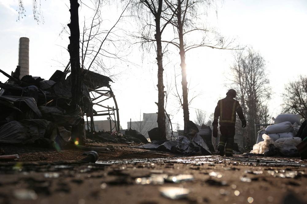 A firefighter works amidst ruins caused by a Russian drone strike in an industrial area, amid Russia's attack on Ukraine, in Kharkiv, Ukraine on March 27. Reuters