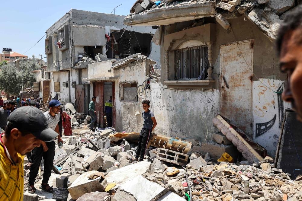 People inspect the damage at the site of an Israeli strike that targeted a house in the Nuseirat camp for Palestinian refugees in the central Gaza Strip on Sunday. AFP