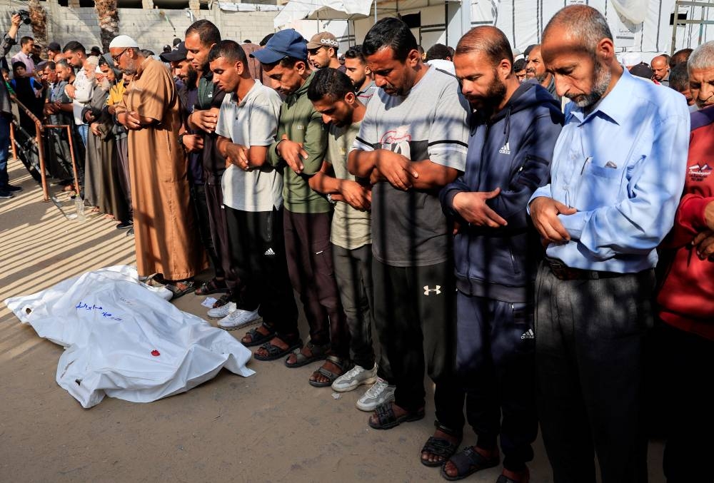 Mourners pray during the funeral of Palestinians who, according to medics, were killed in Israeli strikes, at Nasser hospital, in Khan Younis, in the southern Gaza Strip, on Monday. REUTERS