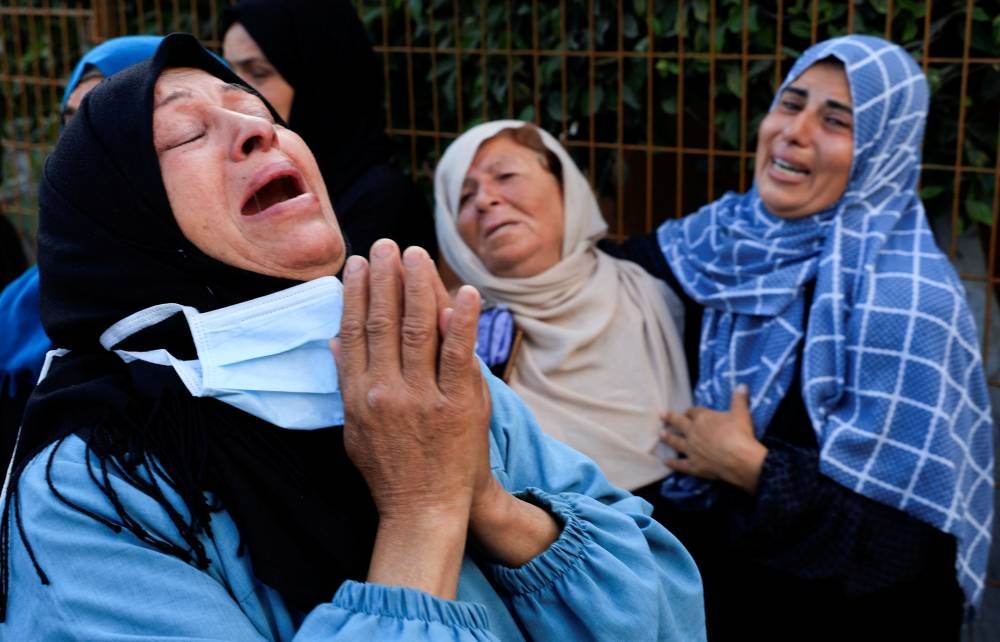 Mourners react during the funeral of Palestinians who, according to medics, were killed in Israeli strikes, at Nasser hospital, in Khan Younis, in the southern Gaza Strip, on Monday. REUTERS
