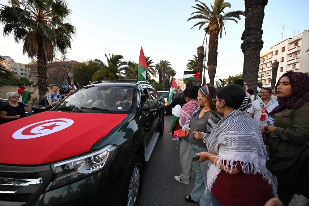 Tunisians gather at a meeting point in Tunis on Monday, ahead of the departure of a land convoy named “Steadfastness” to break the siege on Gaza. AFP