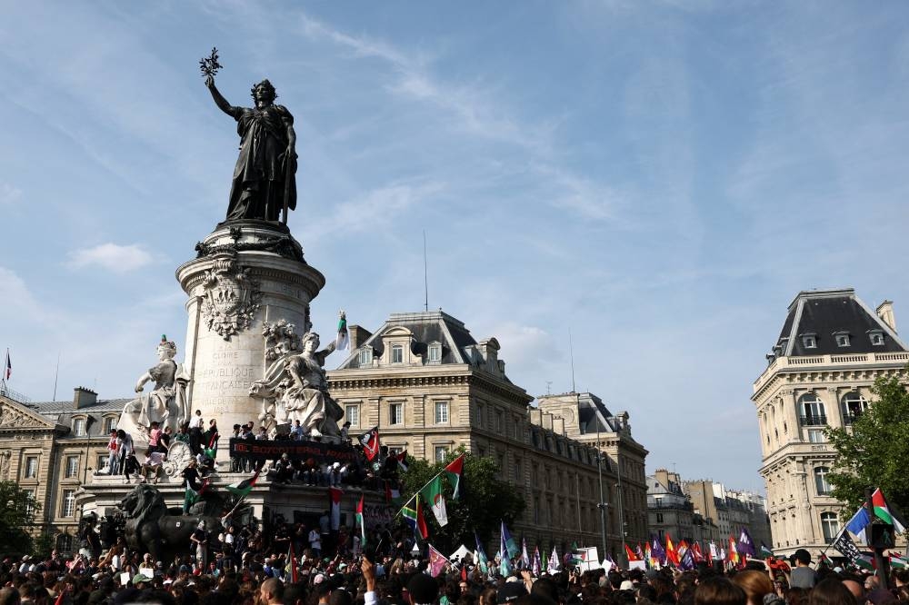 People attend a demonstration to protest after Israeli forces seize the British-flagged yacht, Madleen, which is operated by the pro-Palestinian Freedom Flotilla Coalition, was aiming to deliver a symbolic amount of aid to Gaza later on Monday and raise international awareness of the humanitarian crisis there, at the Place de la Republique in Paris, on Monday. REUTERS