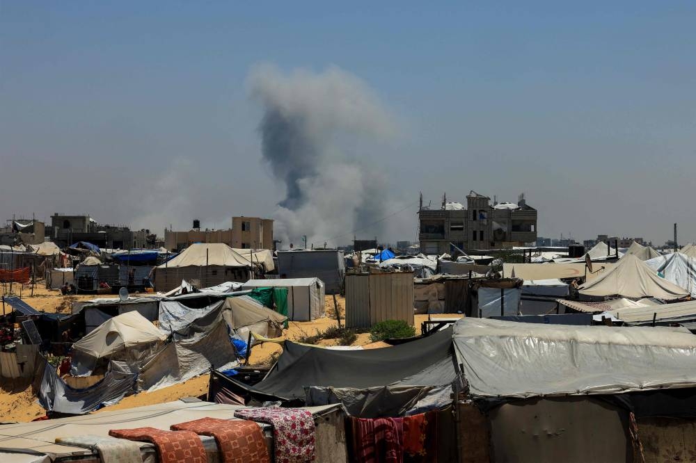 Smoke billows close to shelters of displaced Palestinians during Israeli bombardment in Rafah, in the southern Gaza Strip on Wednesday. AFP 